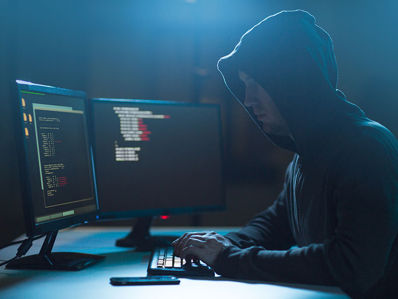 Hacker in a hoodie writing code